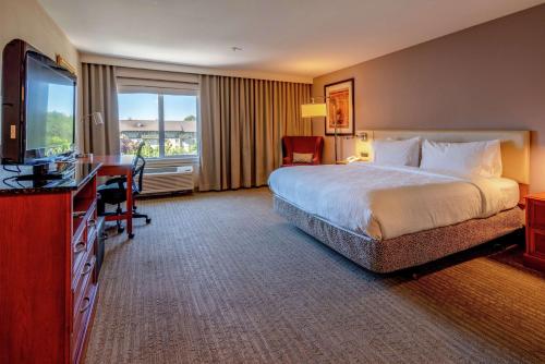 a hotel room with a bed and a television at Hilton Garden Inn Seattle/Renton in Renton