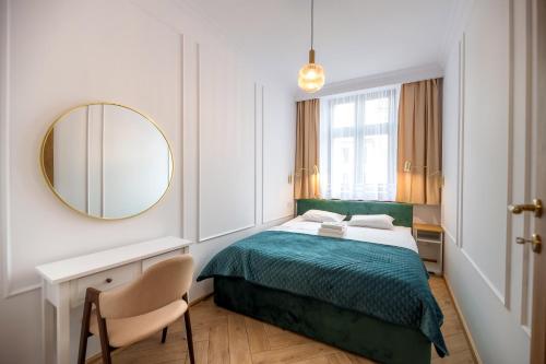 a bedroom with a bed and a mirror and a chair at Tajemniczy Ogród (w sercu toruńskiej Starówki) in Toruń