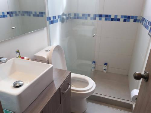 een badkamer met een wastafel, een toilet en een douche bij Hermoso, Apacible - Apartamento Central - Tunja in Tunja