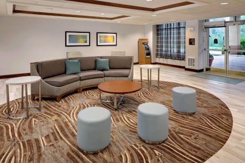 a living room with a couch and tables and stools at Homewood Suites by Hilton - Boston/Billerica-Bedford in Billerica