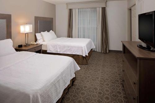 a hotel room with two beds and a flat screen tv at Homewood Suites by Hilton - Boston/Billerica-Bedford in Billerica