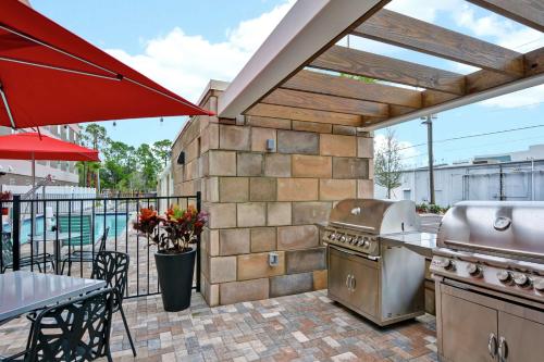 a patio with a grill and a table and a table and a table at Home2 Suites By Hilton Daytona Beach Speedway in Daytona Beach