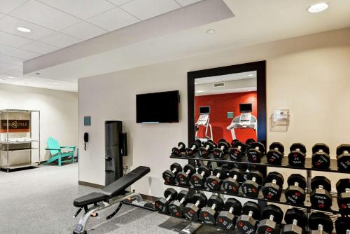 a gym with a wall of exercise equipment at Home2 Suites By Hilton Daytona Beach Speedway in Daytona Beach
