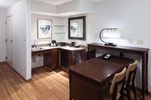 a bathroom with a desk and a sink and a table at Embassy Suites Anchorage in Anchorage