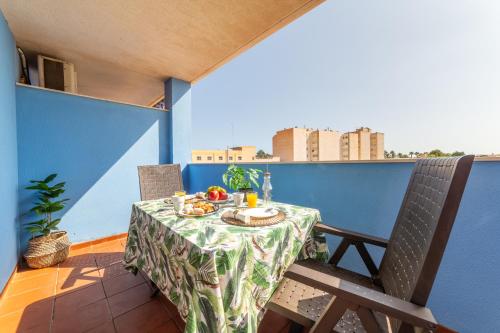 a table on a balcony with a plate of food on it at Apartamento cerca de una de las mejores playas. in Roquetas de Mar