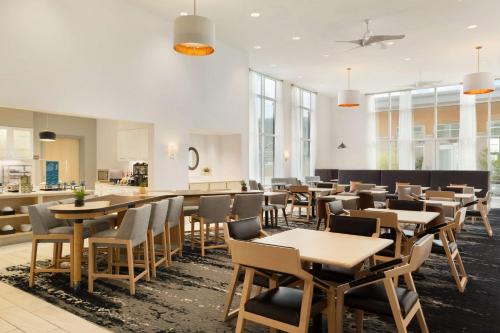 a restaurant with tables and chairs and a kitchen at Homewood Suites By Hilton SLC/Draper in Draper