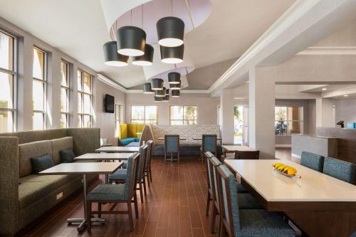 ハリウッドにあるHampton Inn & Suites Fort Lauderdale Airportのテーブルと椅子と窓のあるダイニングルーム