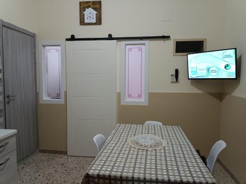 um quarto com uma mesa e uma televisão na parede em Holiday home La Rinascita em Bagheria