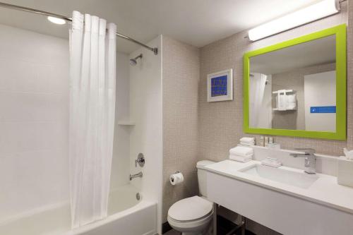 een badkamer met een wastafel, een toilet en een spiegel bij Hampton Inn & Suites Fort Lauderdale Airport in Hollywood