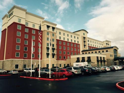 un grande edificio con auto parcheggiate in un parcheggio di Embassy Suites Portland/Hillsboro a Hillsboro