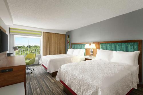 a hotel room with two beds and a window at Hampton Inn & Suites Fort Lauderdale Airport in Hollywood