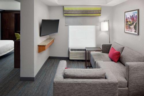 a hotel room with a couch and a tv at Hampton Inn & Suites Houston-Medical Center-NRG Park in Houston