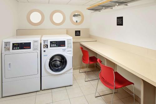 a laundry room with a washing machine and two red chairs at Hampton Inn & Suites Houston-Medical Center-NRG Park in Houston