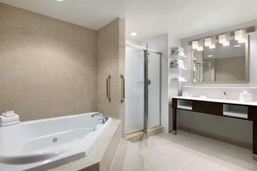 y baño con bañera, ducha y lavamanos. en Hampton Inn Long Island-Brookhaven en Farmingville