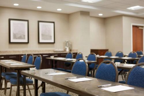 a conference room with tables and blue chairs at Hampton Inn Long Island-Brookhaven in Farmingville