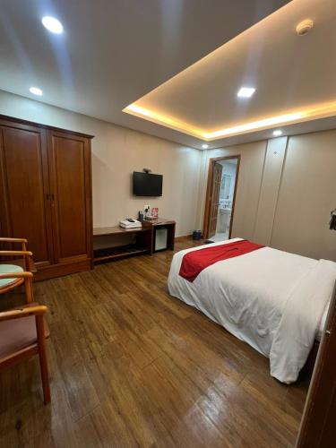ホーチミン・シティにあるQuynh Giang Hoang Vietのベッドとテレビが備わるホテルルームです。