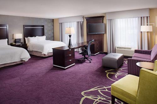 a hotel room with two beds and a desk at Hampton Inn & Suites Lansing West in Lansing