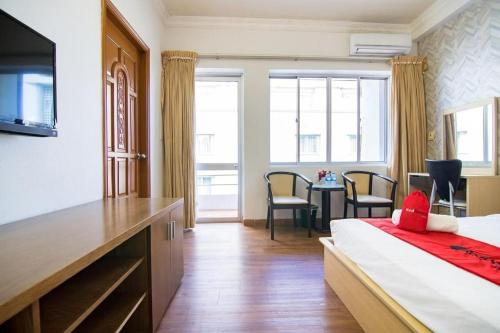 ein Hotelzimmer mit einem Bett und einem Tisch mit Stühlen in der Unterkunft Quynh Giang Hoang Viet in Ho-Chi-Minh-Stadt