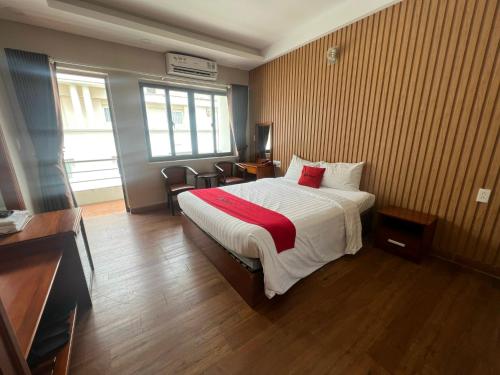 ein Hotelzimmer mit einem Bett mit einer roten Decke in der Unterkunft Quynh Giang Hoang Viet in Ho-Chi-Minh-Stadt