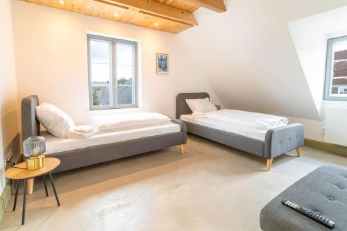 2 camas en una habitación con 2 ventanas en Ferienwohnung Schiffbrücke 40, en Flensburg