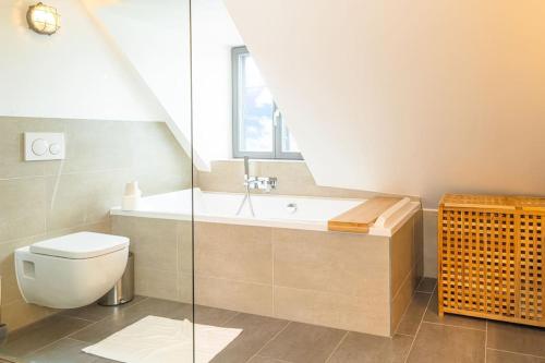 a bathroom with a toilet and a sink and a window at Ferienwohnung Schiffbrücke 40 in Flensburg