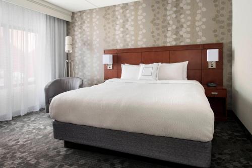 a bedroom with a large bed and a large window at Courtyard by Marriott Boston Norwood/Canton in Norwood