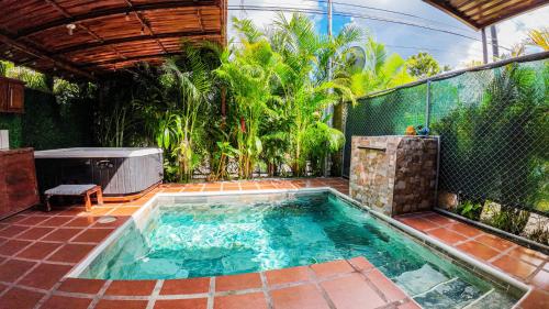 a small swimming pool in a backyard with trees at Bungalows Las Iguanas Arenal Volcano in Chachagua