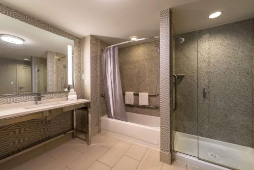 a bathroom with a shower and a sink and a tub at Hilton Garden Inn Portsmouth Downtown in Portsmouth