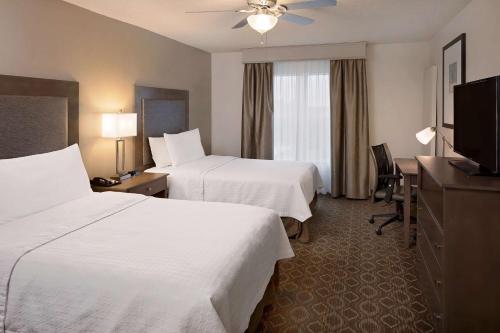 a hotel room with two beds and a television at Homewood Suites by Hilton Orlando Maitland in Orlando