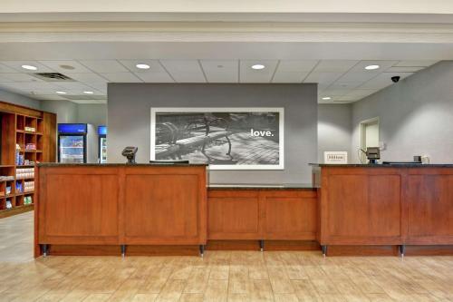 a lobby with a waiting area with a sign that says loves at Hampton Inn & Suites Newark-Harrison-Riverwalk in Newark