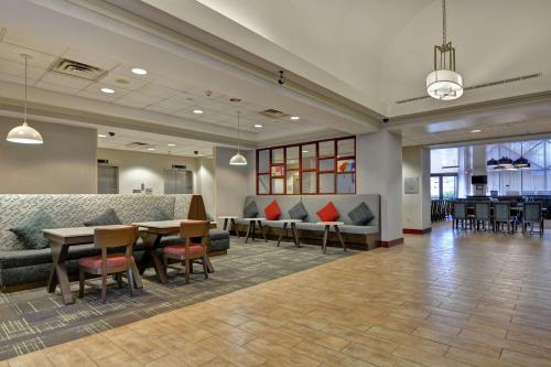 um átrio com sofás, uma mesa e cadeiras em Hampton Inn & Suites Newark-Harrison-Riverwalk em Newark