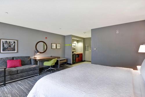 ニューアークにあるハンプトン イン ＆ スイーツ ニューアーク ハリソン リバーウォークのベッドとデスクが備わるホテルルームです。