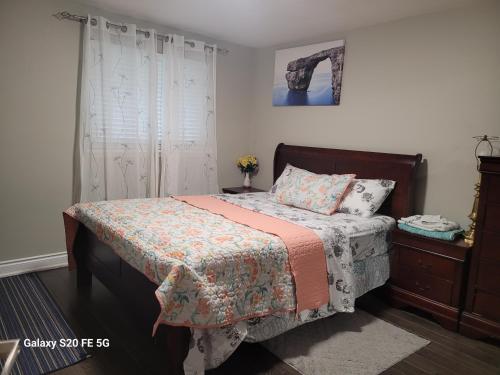 um quarto com uma cama com um cobertor e uma cómoda em Nice private 2 bedrooms appartment em Oshawa
