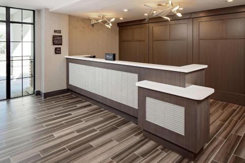 an office lobby with a reception counter and wood floors at Homewood Suites By Hilton Ronkonkoma in Ronkonkoma