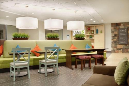 a waiting room with a couch and a table and chairs at Home2 Suites by Hilton Seattle Airport in Tukwila