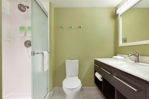 a bathroom with a toilet and a glass shower at Home2 Suites by Hilton Seattle Airport in Tukwila