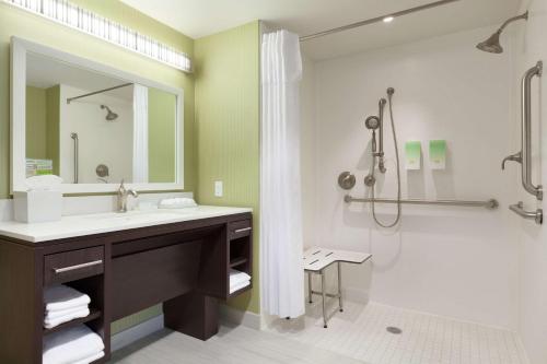 uma casa de banho com um lavatório e um chuveiro em Home2 Suites by Hilton Seattle Airport em Tukwila
