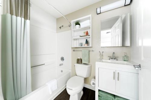 a white bathroom with a toilet and a sink at InTown Suites Extended Stay Baton Rouge LA in Baton Rouge