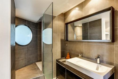 une salle de bain avec un lavabo et un miroir dans l'établissement Appartement d'exception Paris 20ème, terrasse de 45m2, vue sur la Tour Eiffel, à Paris