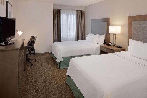 Habitación de hotel con 2 camas y TV de pantalla plana. en Homewood Suites by Hilton Minneapolis-Mall Of America en Bloomington