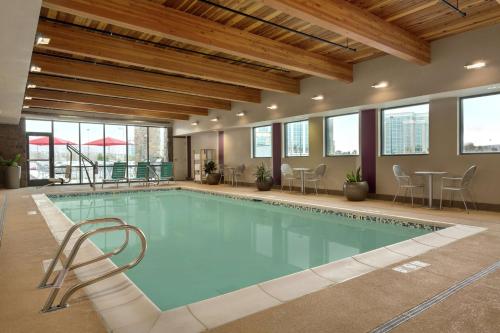 una gran piscina con sillas y mesas en un edificio en Home2 Suites by Hilton Salt Lake City / South Jordan, en South Jordan