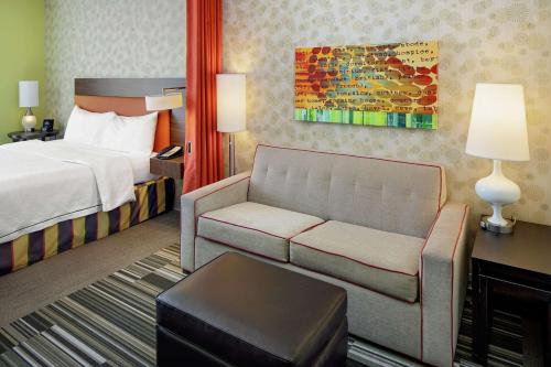 a hotel room with a bed and a couch at Home2 Suites by Hilton Salt Lake City / South Jordan in South Jordan