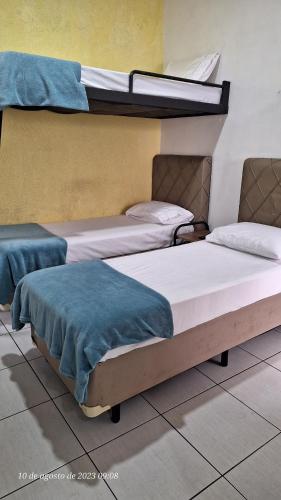 duas camas sentadas num quarto com em Hospedagem Camisa 10 em Santos