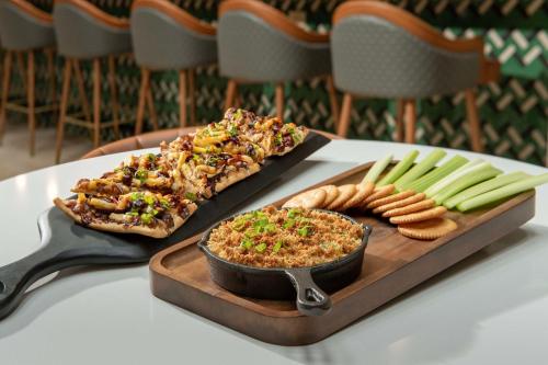 a table topped with two slices of pizza and dip and celery sticks at Embassy Suites by Hilton Dulles North Loudoun in Ashburn