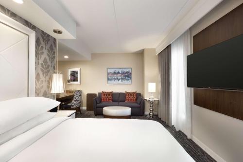 ダルースにあるEmbassy Suites by Hilton Atlanta NE Gwinnett Sugarloafのベッドとソファ付きのホテルルーム