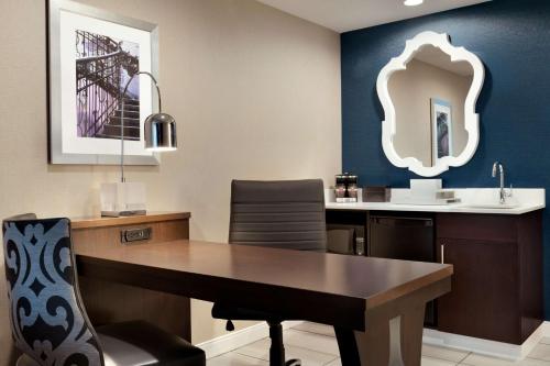 a dining room with a table and a mirror at Embassy Suites by Hilton Atlanta NE Gwinnett Sugarloaf in Duluth