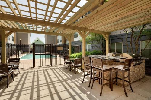 a patio with a wooden pergola and a table and chairs at Homewood Suites by Hilton Dulles-North Loudoun in Ashburn