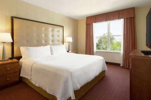a hotel room with a large bed and a window at Homewood Suites by Hilton Dulles-North Loudoun in Ashburn