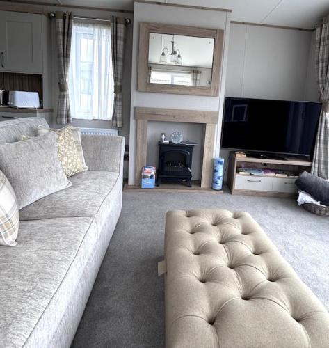 a living room with a couch and a television at Sandy Toes, Padstow in Padstow