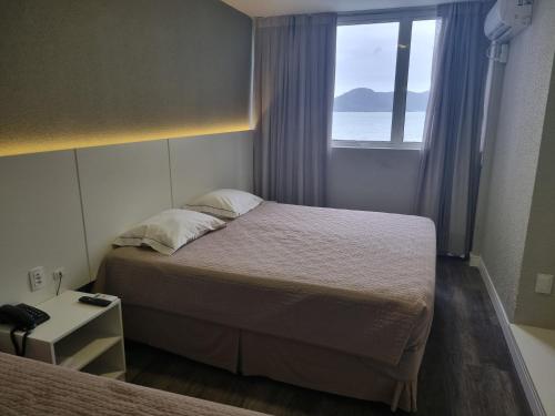 a hotel room with two beds and a window at Marambaia Hotel e Convenções in Balneário Camboriú